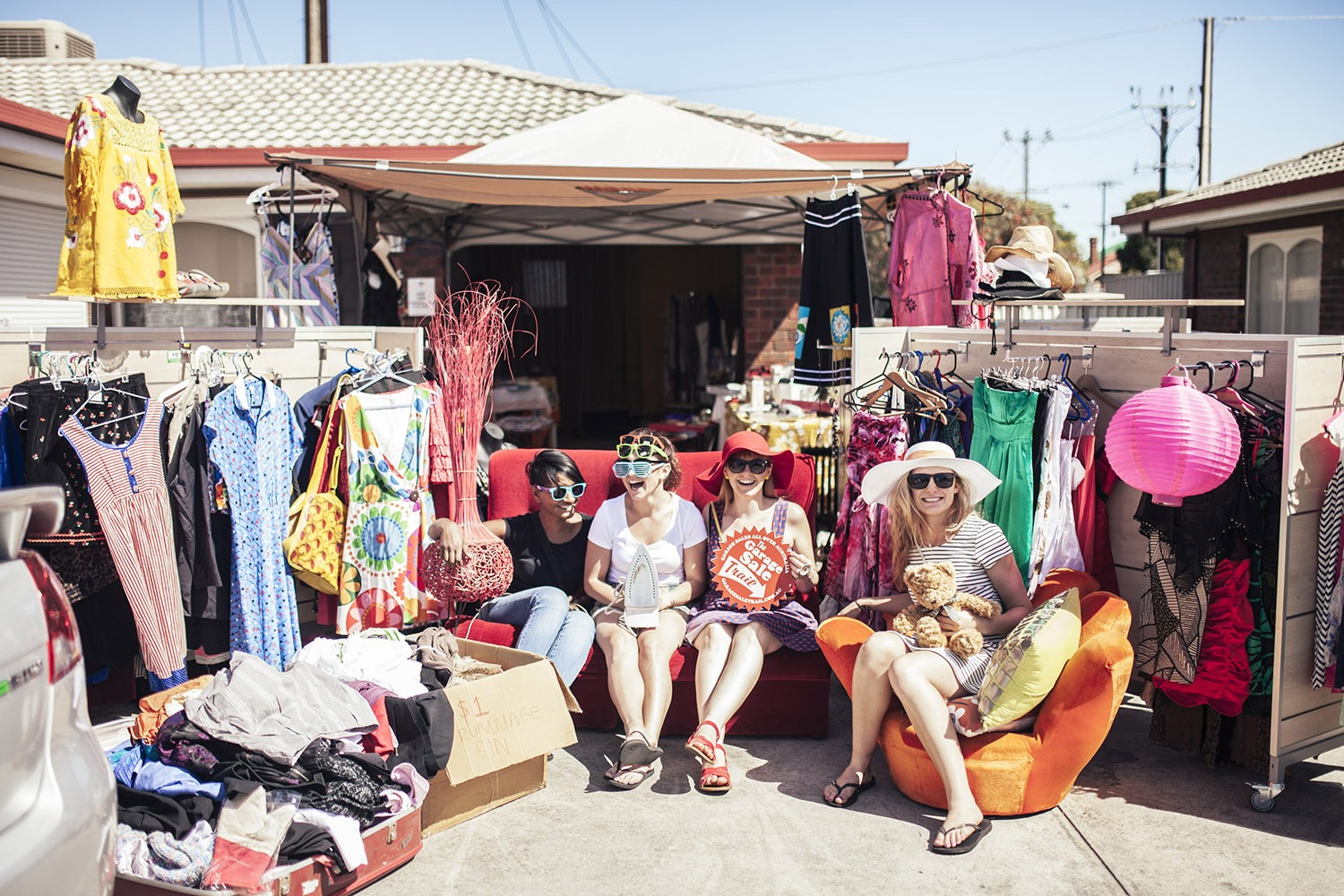 four friends smiling surrounded by various items