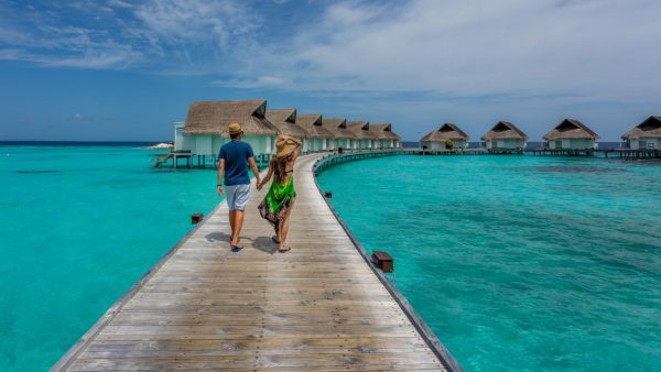 a man and woman tourist walking towards cottages