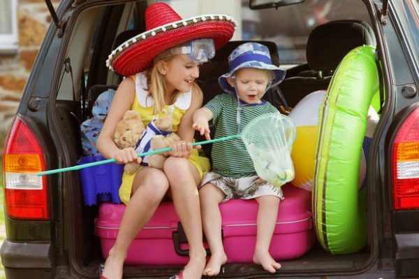 two siblings at the back of their car ready for the beach