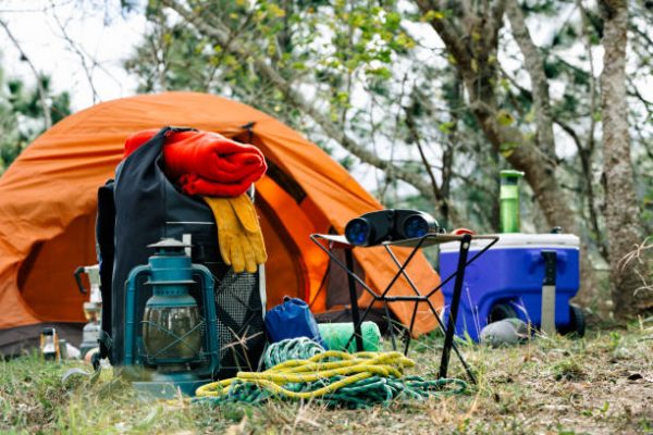 a tent set up at a camp site with scattered camping supplies